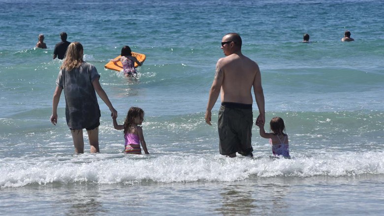 Families take refuge in cool ocean waves at La Jolla Shores to escape high temperatures. Photo by Chris Stone