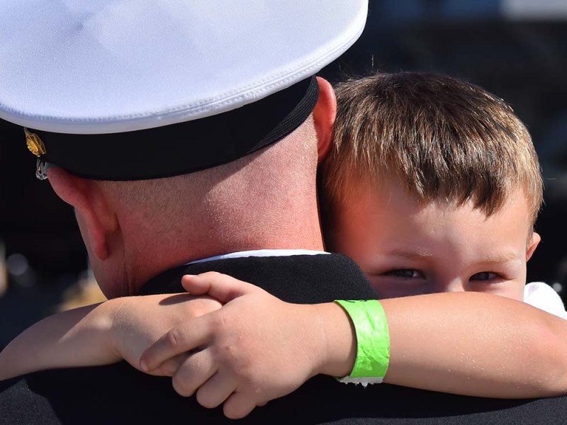 Julian Blodgett, 4, hangs on tight to his father after his return to San Diego. Photo by Chris Stone